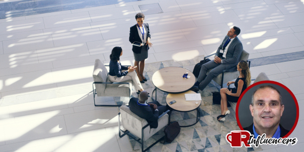 Professionals holding a meeting in a circle, John Kenney’s headshot overlayed Professionals holding a meeting in a circle, John Kenney’s headshot overlayed